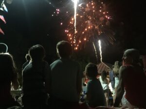 kids sitting on a dock watching 4th of July fireworks at Baytowne Wharf